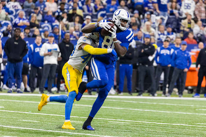 Dec 26, 2022; Indianapolis, Indiana, USA; Indianapolis Colts tight end Jelani Woods (80) runs with the ball while Los Angeles Chargers cornerback Michael Davis (43) defends in the first half at Lucas Oil Stadium.